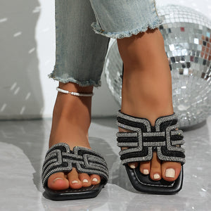 Black open-toe sandals with dazzling rhinestone embellishments on the straps.