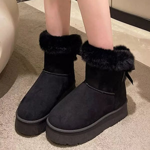Black suede round-toe boots with fur cuff and platform sole.