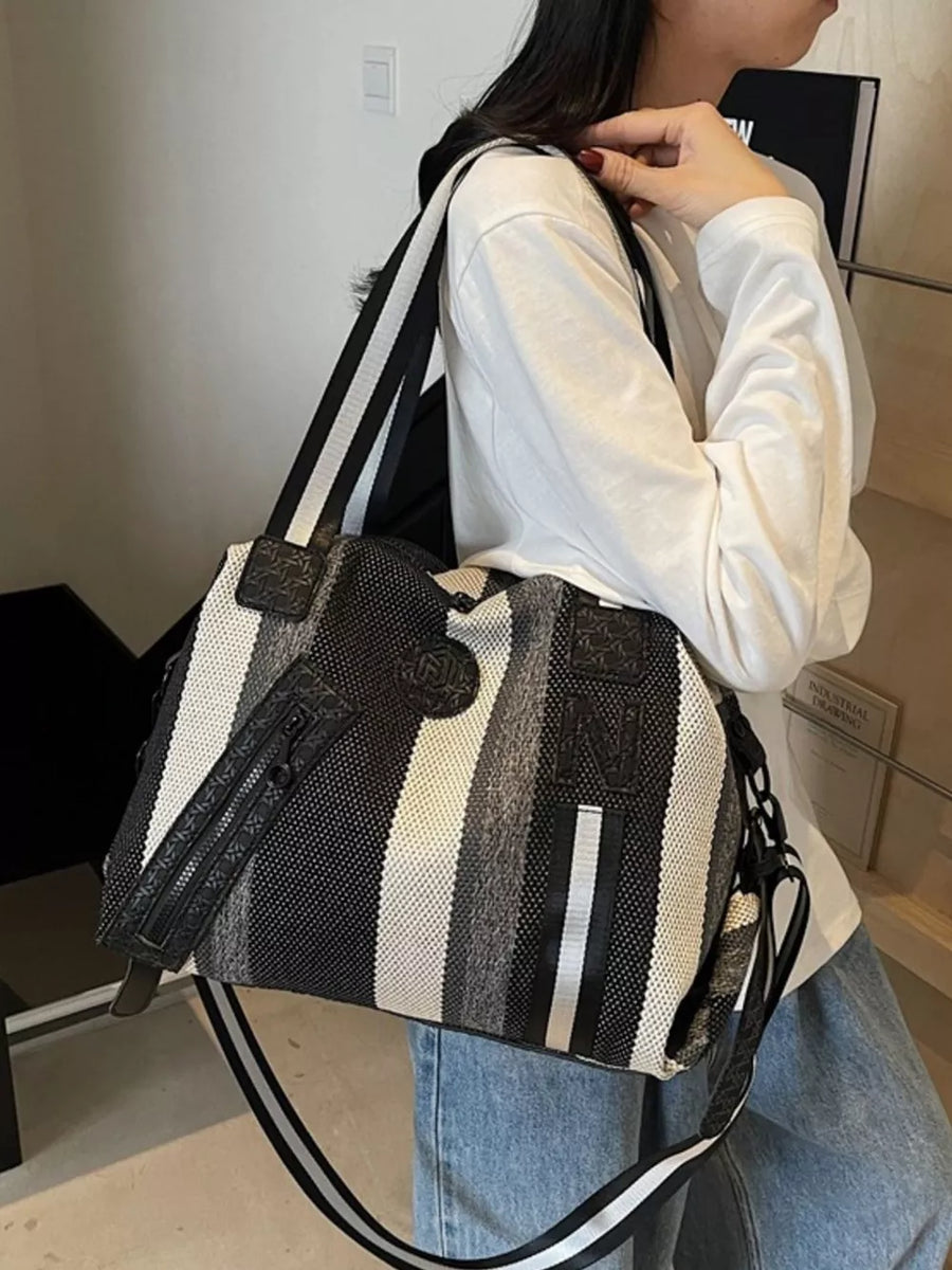 Chic striped medium duffle bag in black and white with a detachable strap.