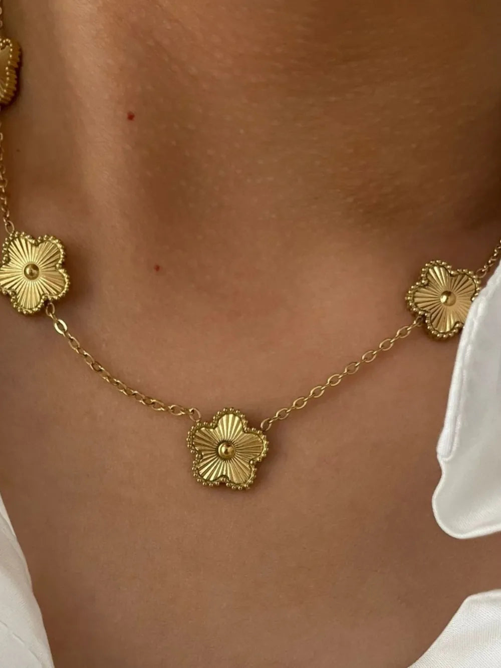 Gold necklace featuring delicate floral charms and floral