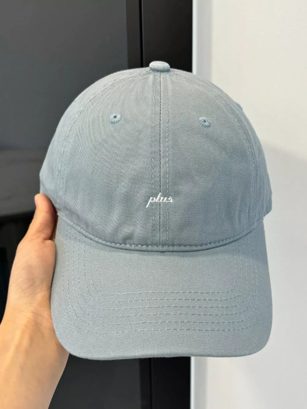 Grey baseball cap with embroidered white "plus" detail
