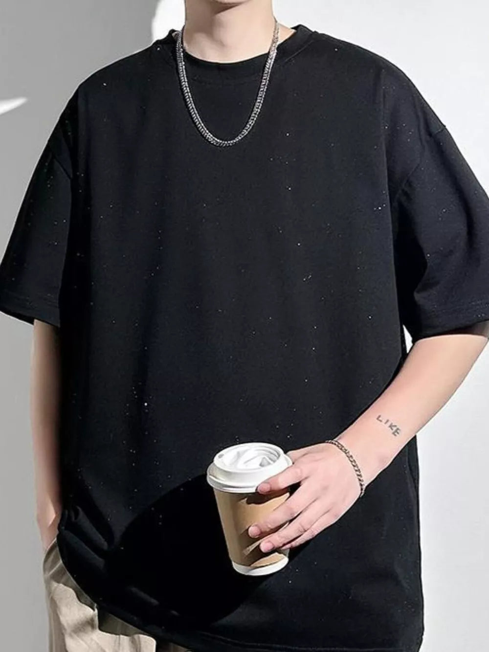 Black oversized cotton t-shirt with subtle distressed details and a crew neck.