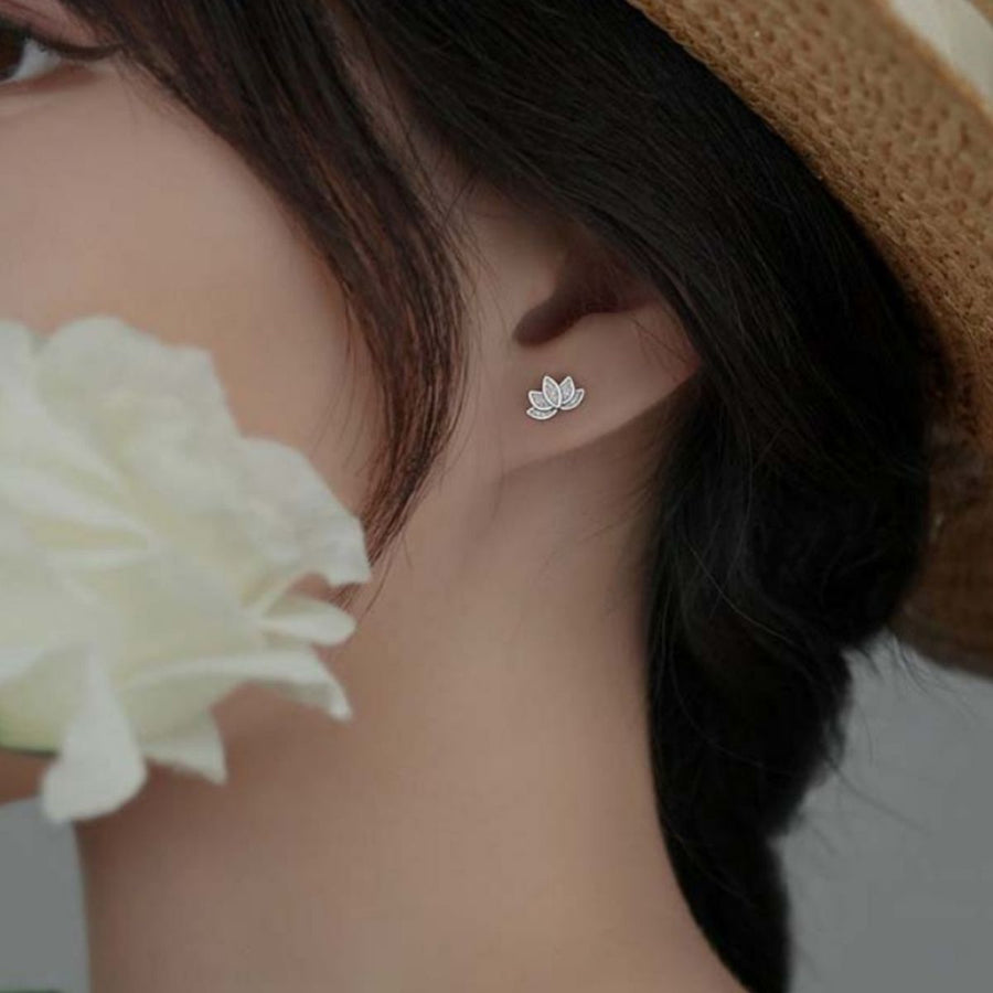 Silver lotus flower stud earrings with delicate petal detail.