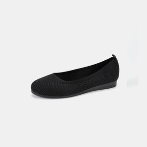 Black textured knit slip-on ballet flats with a round toe and low heel.
