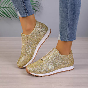 Gold glitter slip-on flats with round toe and elastic detail.