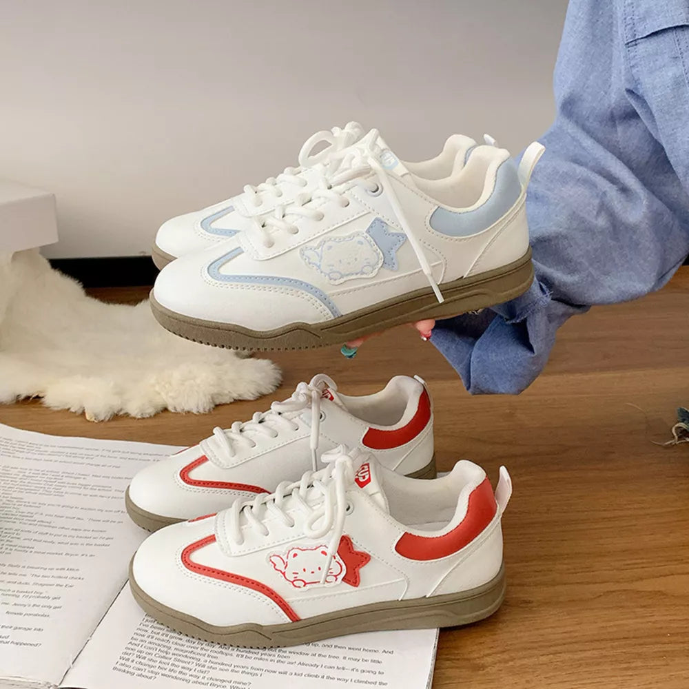 White lace-up sneakers with red or blue cartoon accents and star details.