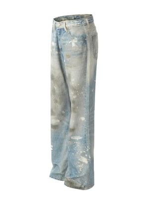 Distressed wash wide leg denim jeans in medium blue with paint splatters and ripped details.