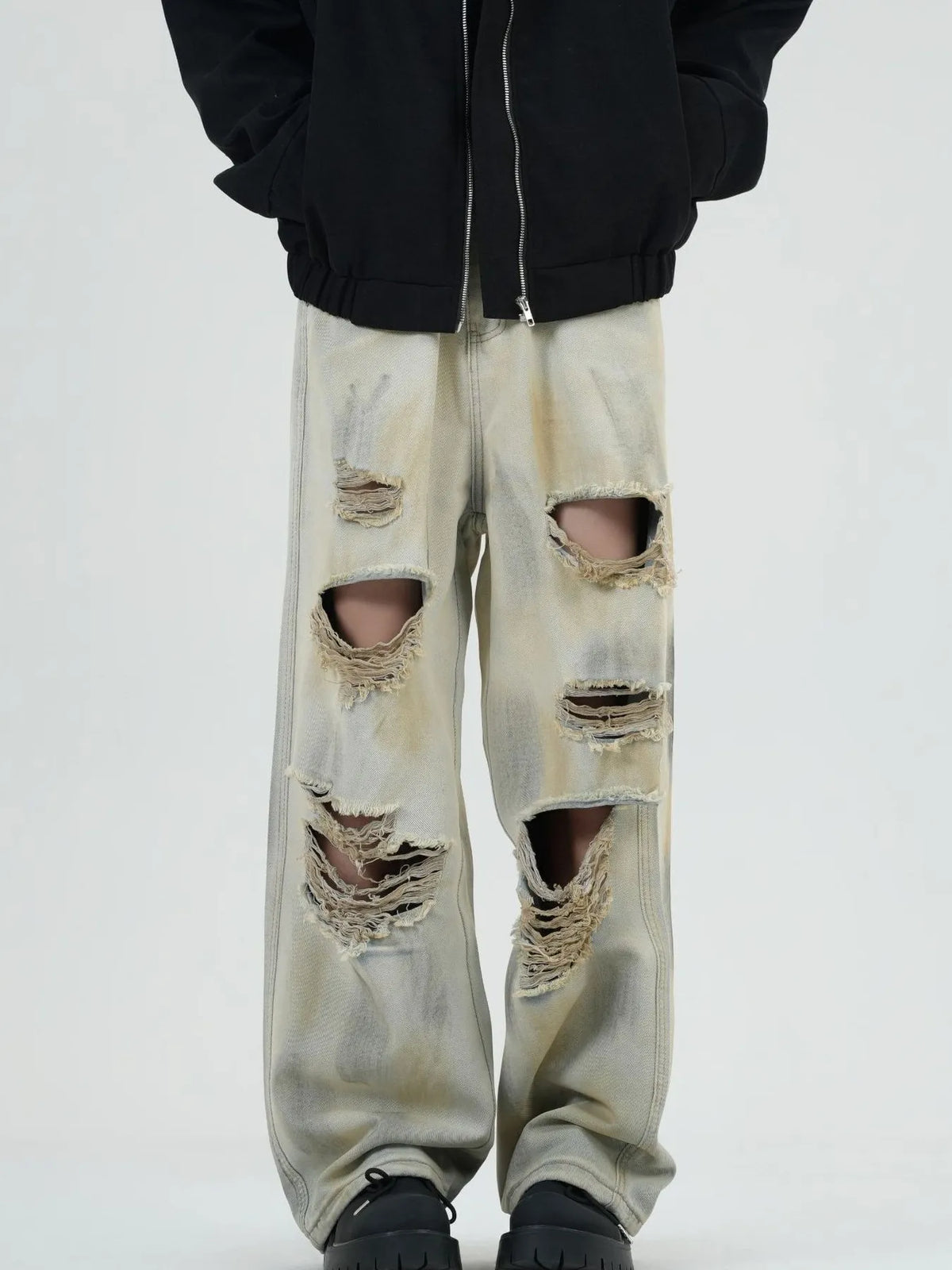 Distressed wide-leg jeans in yellow mud with heavy rips and a washed denim look.