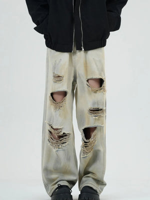 Distressed wide-leg jeans in yellow mud with heavy rips and a washed denim look.