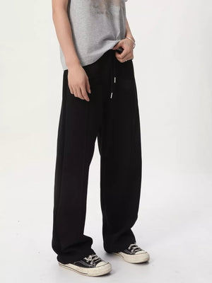 Men's black cotton wide-leg drawstring sweatpants with stitched seams.