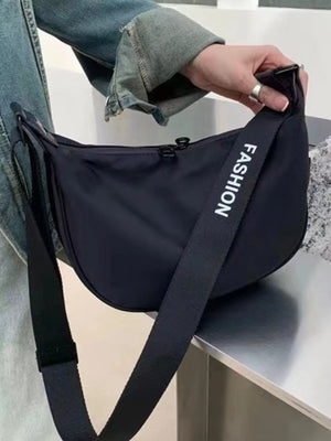 Black crossbody bag with adjustable strap and "Fashion" text detail