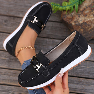 Black slip-on loafers with buckle detail and contrast stitching.