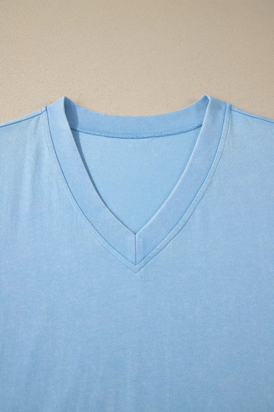 Light blue cotton v-neck top with relaxed fit and double-stitched neckline detail.