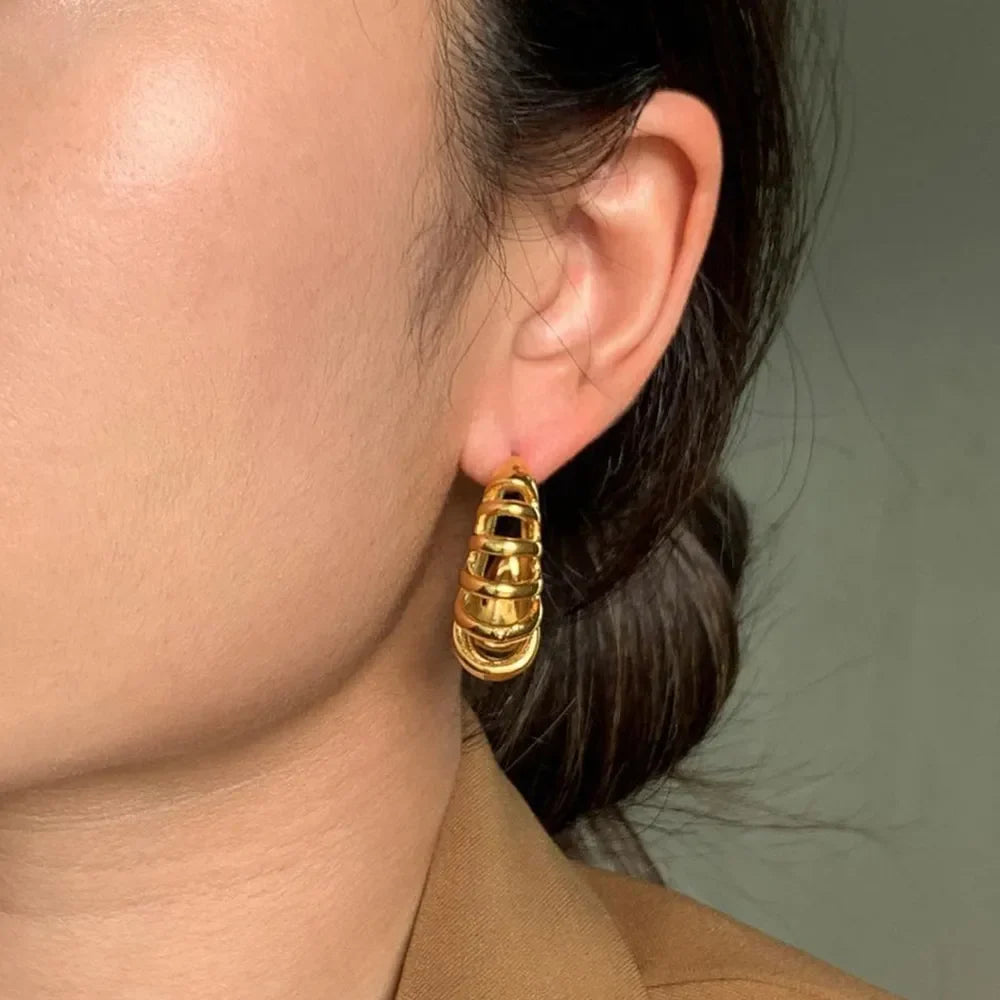 Sculptural ribbed gold hoop earrings with stacked rings, 18K gold-plated.