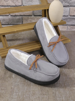 Gray suede moccasin slippers with white faux fur lining and a decorative bow.