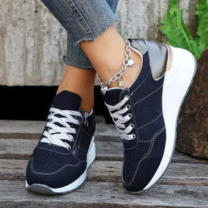 Navy lace-up wedge sneakers with white laces and a side zipper detail.
