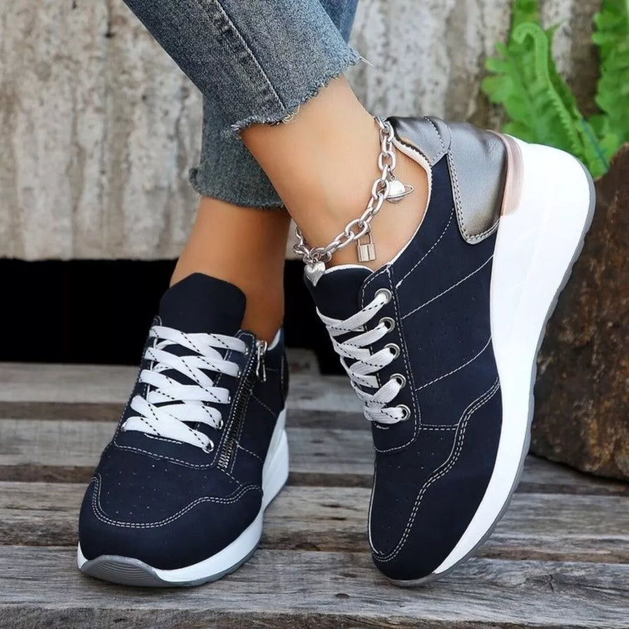 Navy lace-up wedge sneakers with white laces and a side zipper detail.