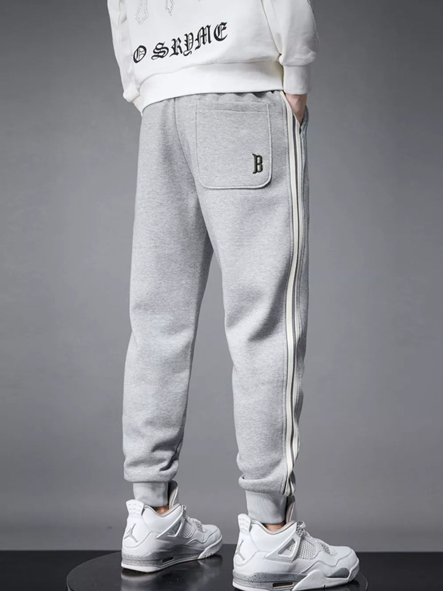 Light gray cotton joggers with side stripe detail and cuffed ankles.