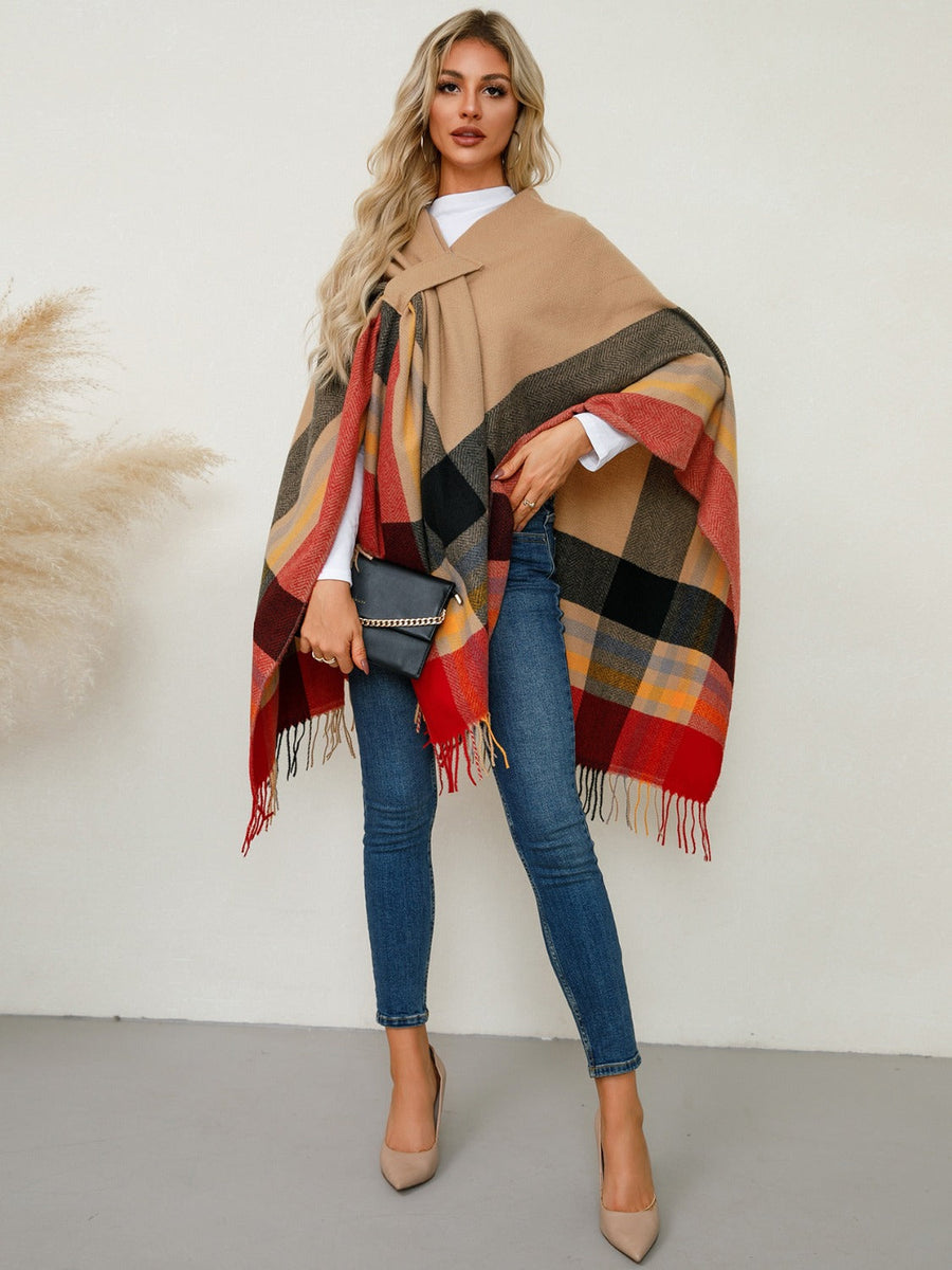 Asymmetric plaid cape in tan with red, black, and yellow checkered pattern and fringe detail.