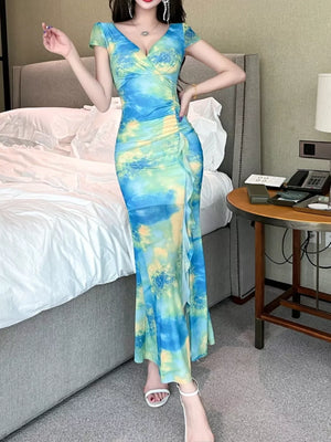 Surplice ruffle maxi dress in blue and green tie-dye with ruched side detail.
