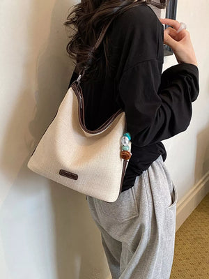 handbag in ivory featuring decorative charm and relaxed fit