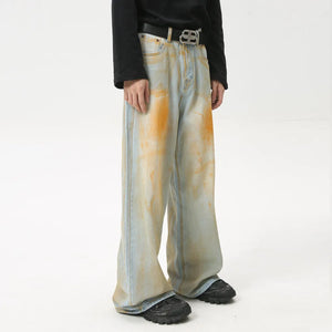 Acid wash palazzo denim jeans in light blue with orange splatters and a wide leg.