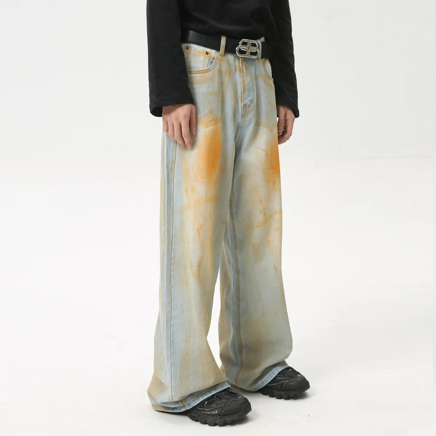 Acid wash palazzo denim jeans in light blue with orange splatters and a wide leg.