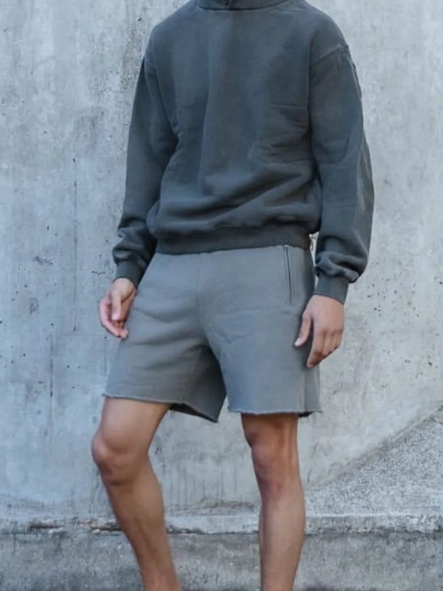 Gray relaxed fit shorts with raw hem and side pockets.