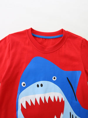 Red cotton t-shirt with a playful blue shark graphic and white teeth detail.