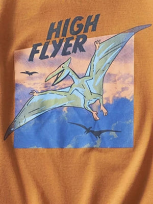Orange t-shirt with a graphic print of a green pterodactyl flying in a blue sky with clouds and text that says HIGH FLYER.