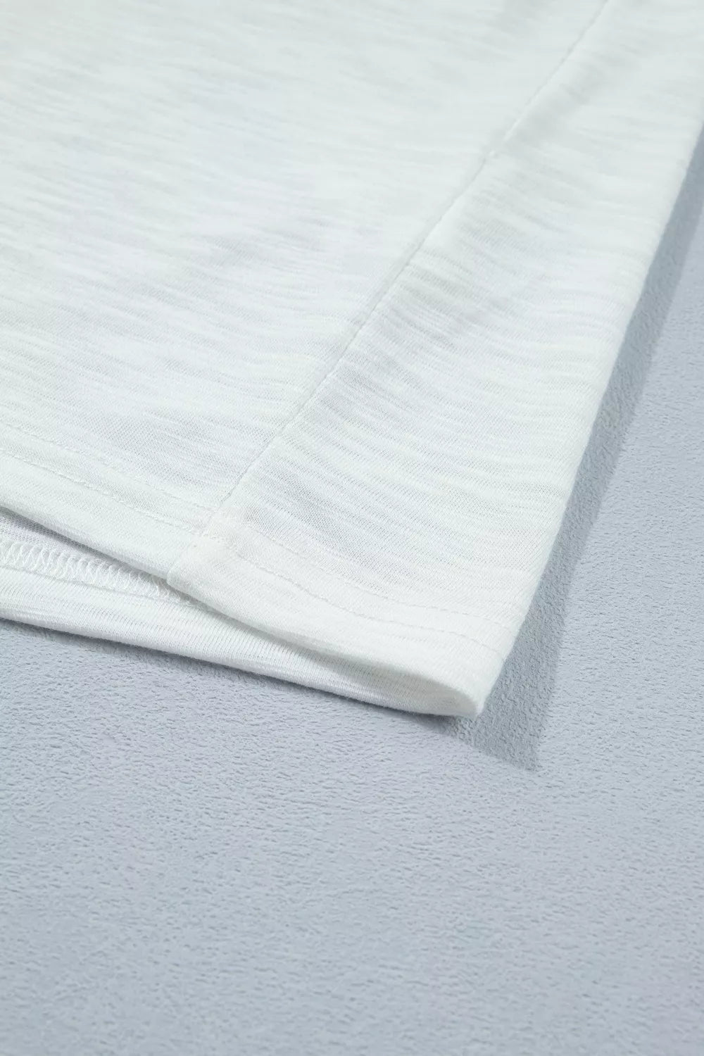 White polyester t-shirt with subtle heathered texture and ruffled detail.