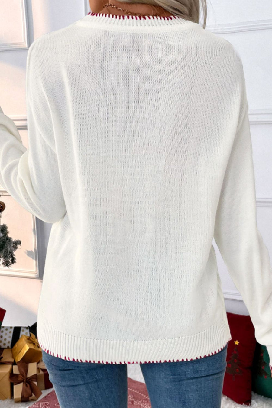 White acrylic knit sweater with festive red trim on neckline and hem.