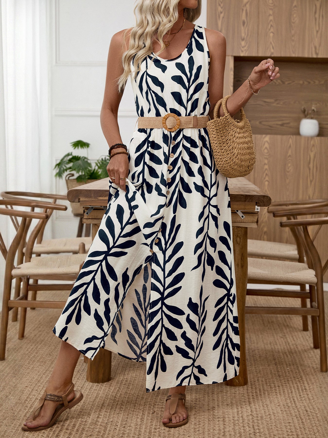 White and navy tropical leaf print belted midi dress with decorative buttons and a straw belt.