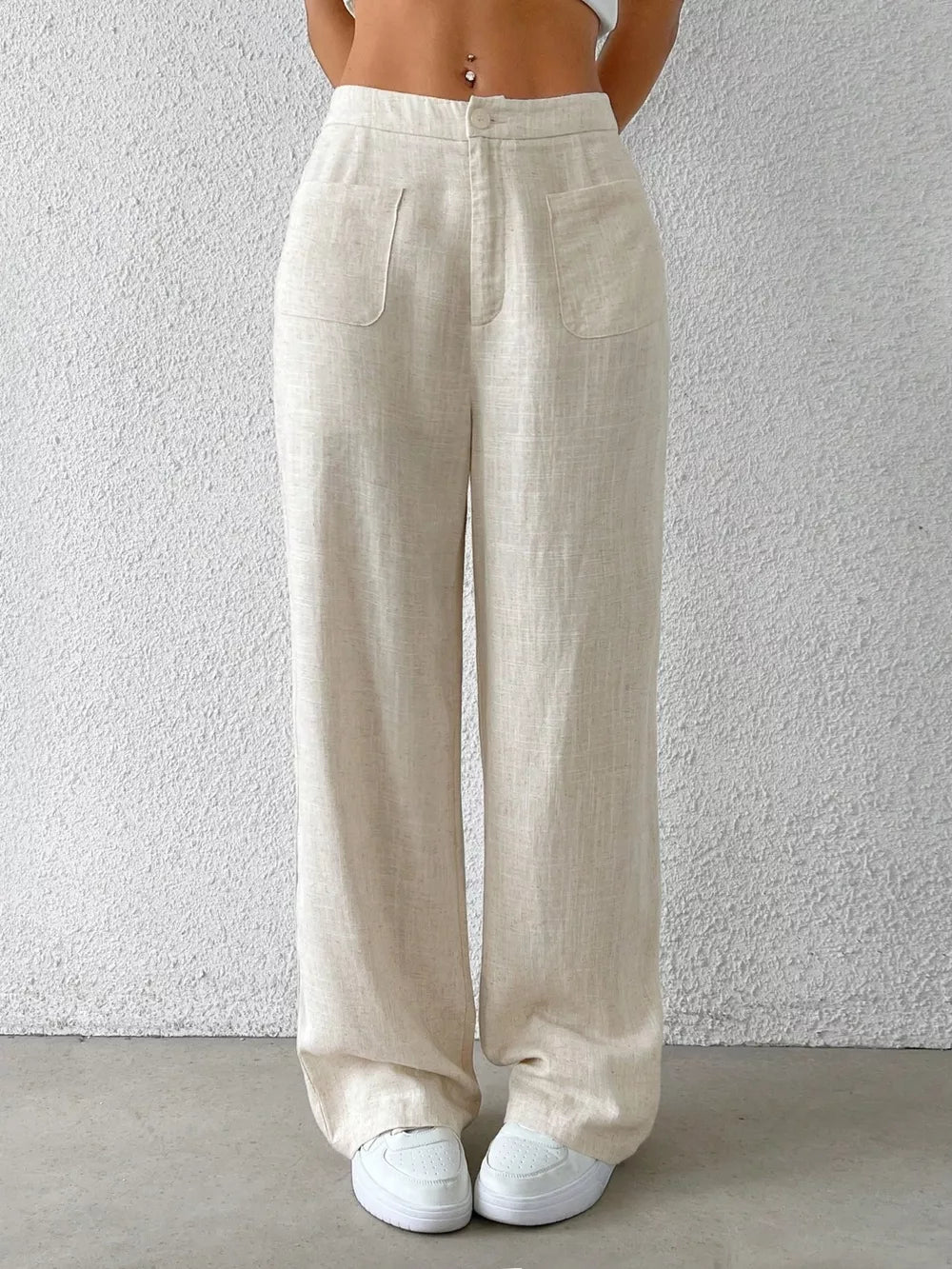 Wide-leg linen pants in beige with button closure and dual front patch pockets.