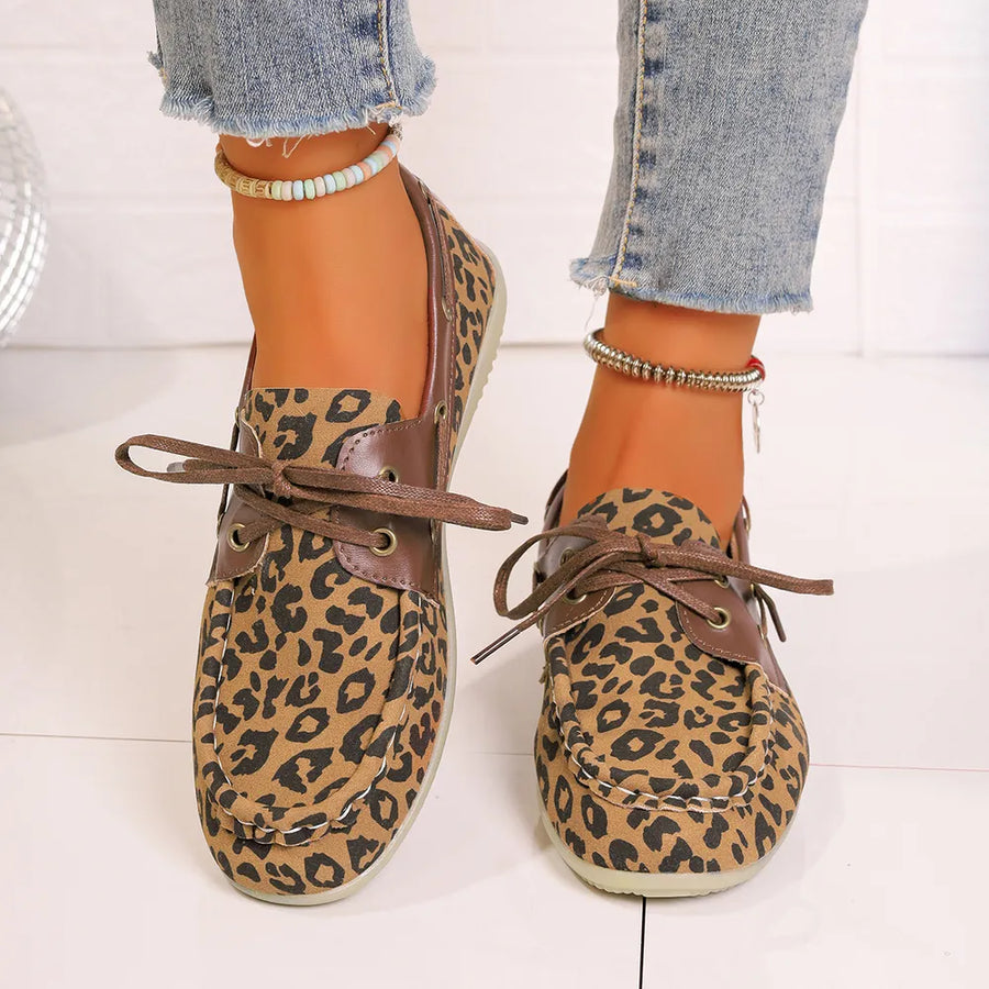 Leopard print boat shoes with leather accents and lace-up detail.