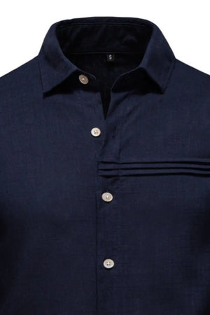 Navy linen shirt with buttoned collar and pleated pocket detail.
