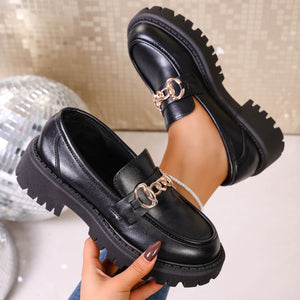 Chunky lug sole loafers in gloss black with gold chain detail.
