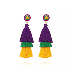Vibrant layered tassel earrings with purple, green, and yellow tassels and beaded studs.