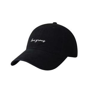 Black cotton baseball cap with embroidered "love grows" text detail.