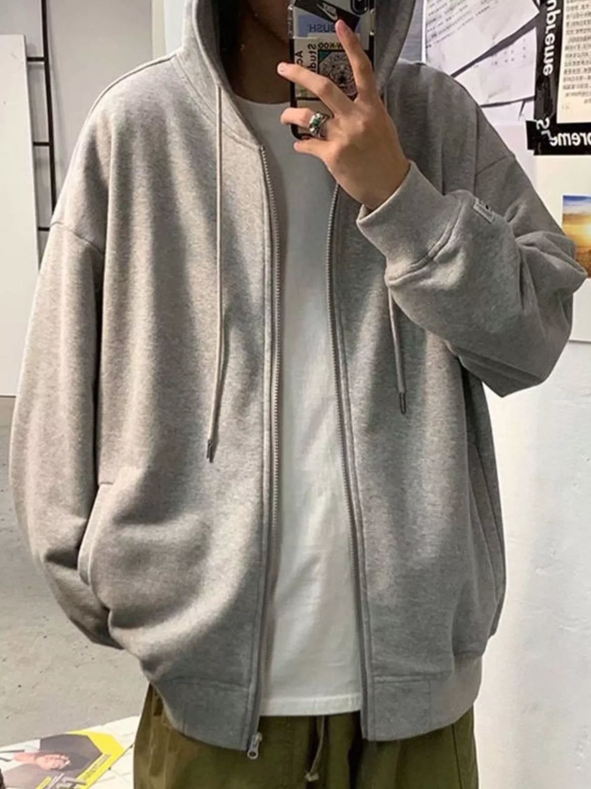 Gray casual zip-up hoodie with drawstring hood and pockets, worn over a white t-shirt.