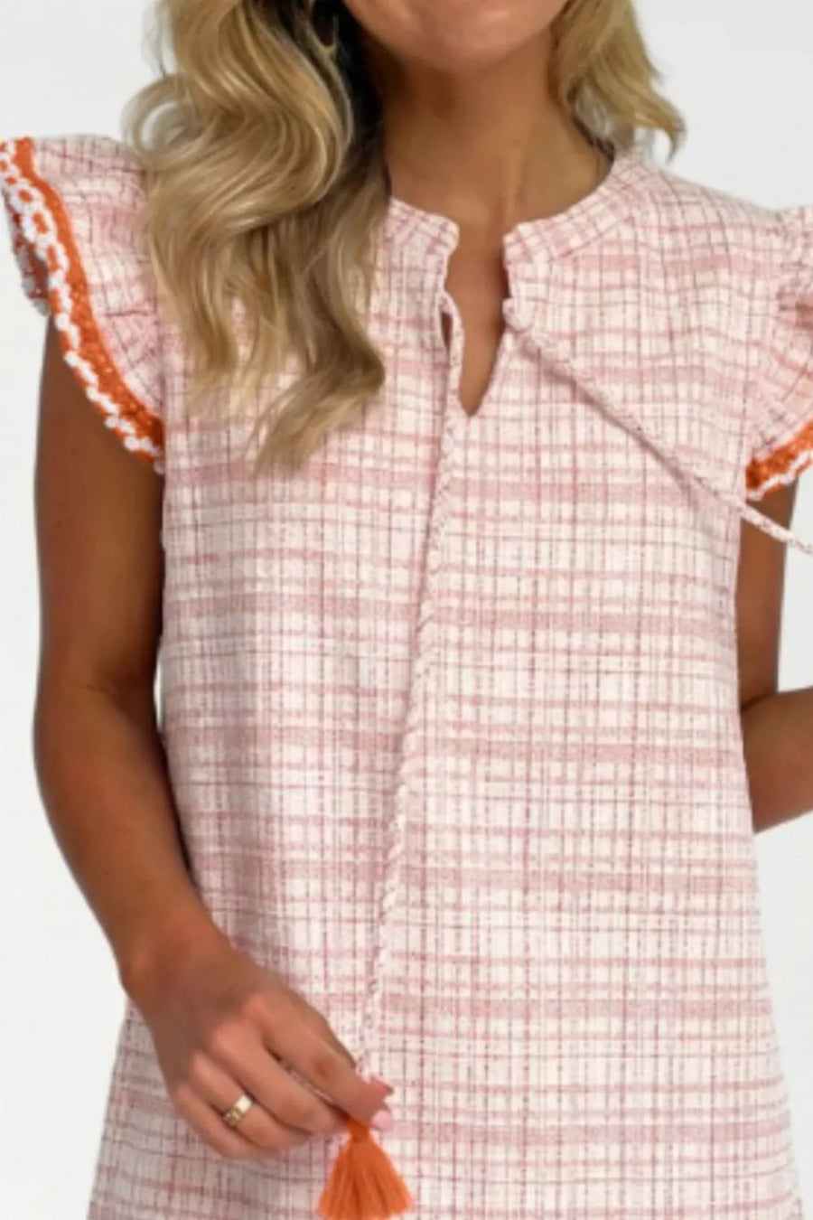 Pink plaid shift dress with ruffled trim and tassel detail