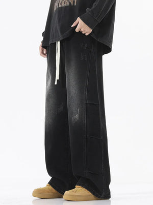 Oversized black vintage wash wide leg jeans with distressed details and drawstring waist.