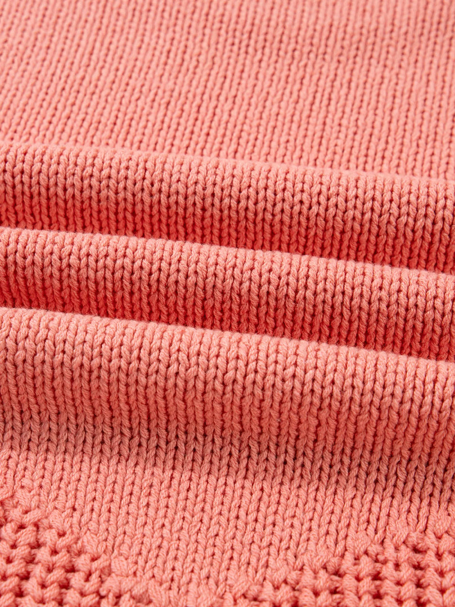 Burnt coral knit sweater with detailed texture and subtle open knit pattern.