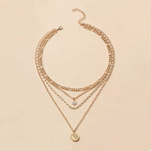 Gold layered coin pendant necklace with a clear stone accent