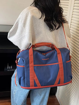 Blue duffel bag with orange trim and handles, featuring "GUOMISS" logo.