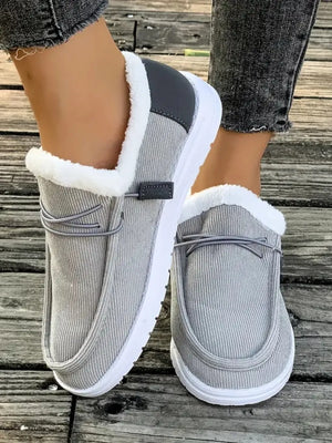 Gray corduroy slip-on sneakers with white sherpa lining and dark gray heel accent.