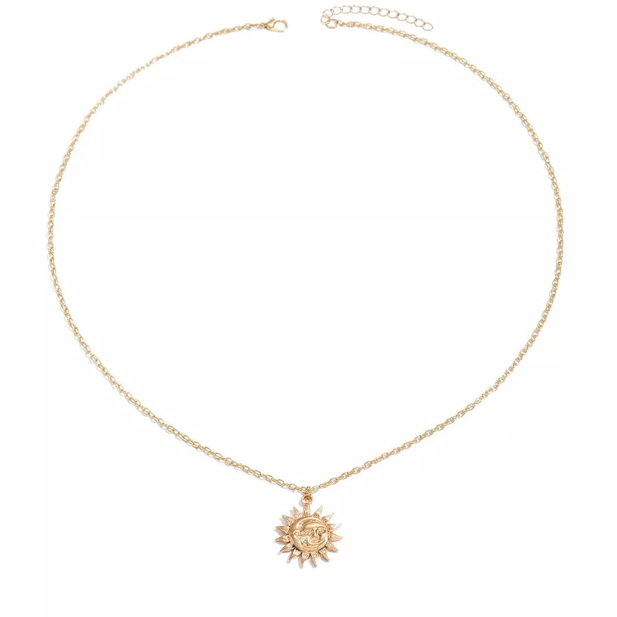 Gold sunburst pendant necklace with a celestial face detail on a delicate chain.