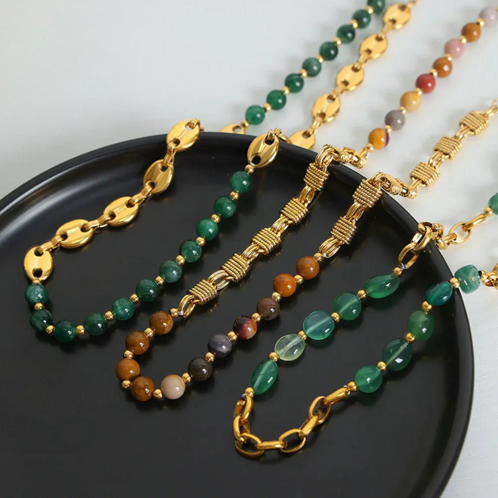 Gilded bead and chain statement necklace with green and mustard beads and gold accents.