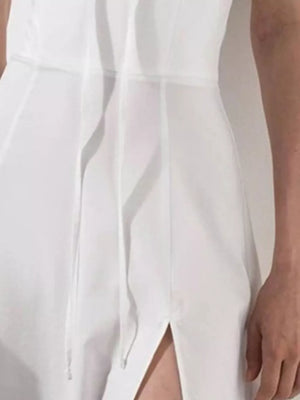 White midi dress with tie front, puff sleeves, and thigh-high slit.