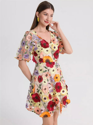 Sheer floral embroidered mini dress with V-neck and puff sleeves.